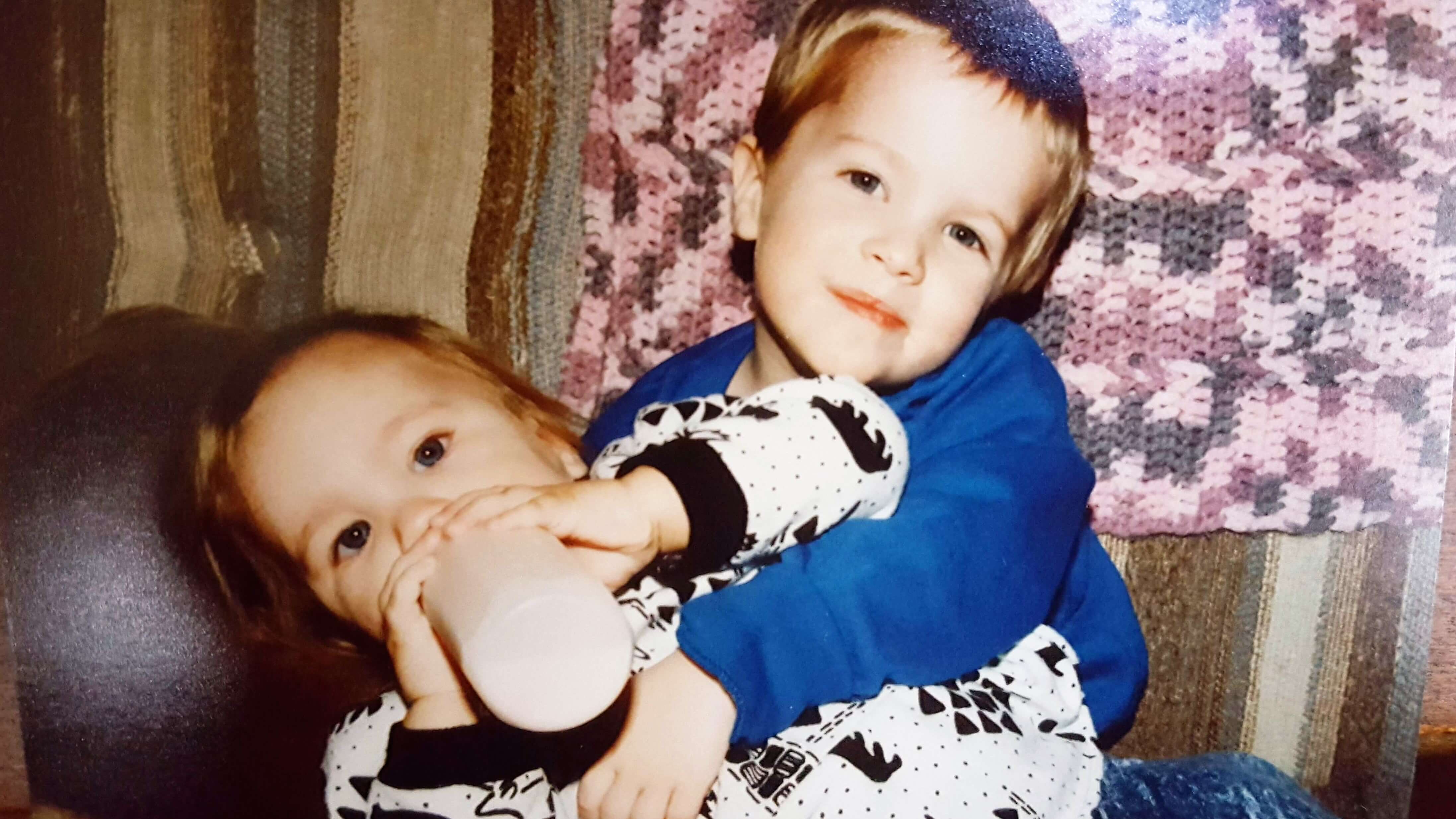 Big brother holds little sister who is almost as big as he is